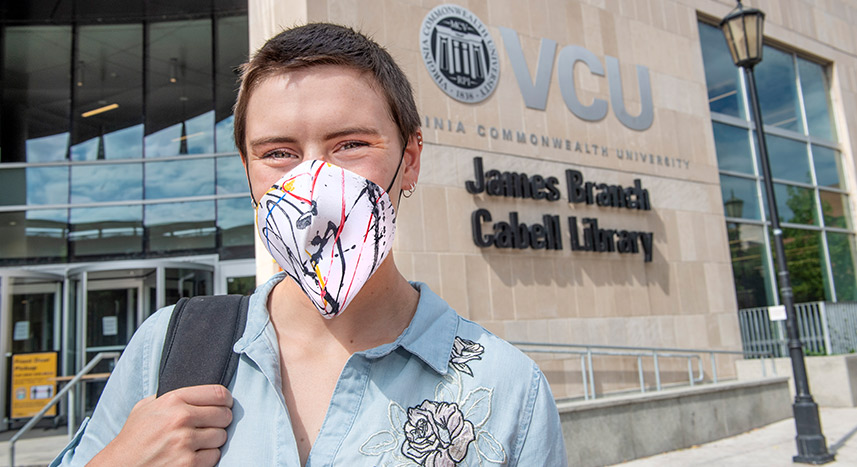 Student wearing mask standing outside on campus